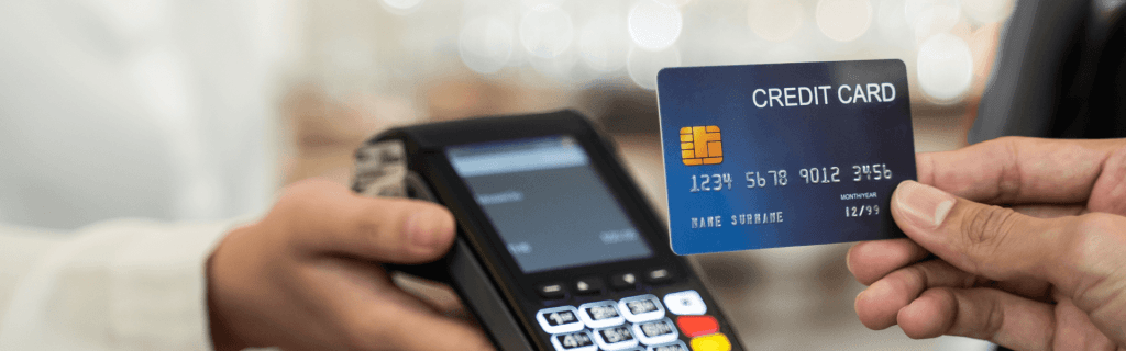 A hand holding a chip card up to a payment terminal
